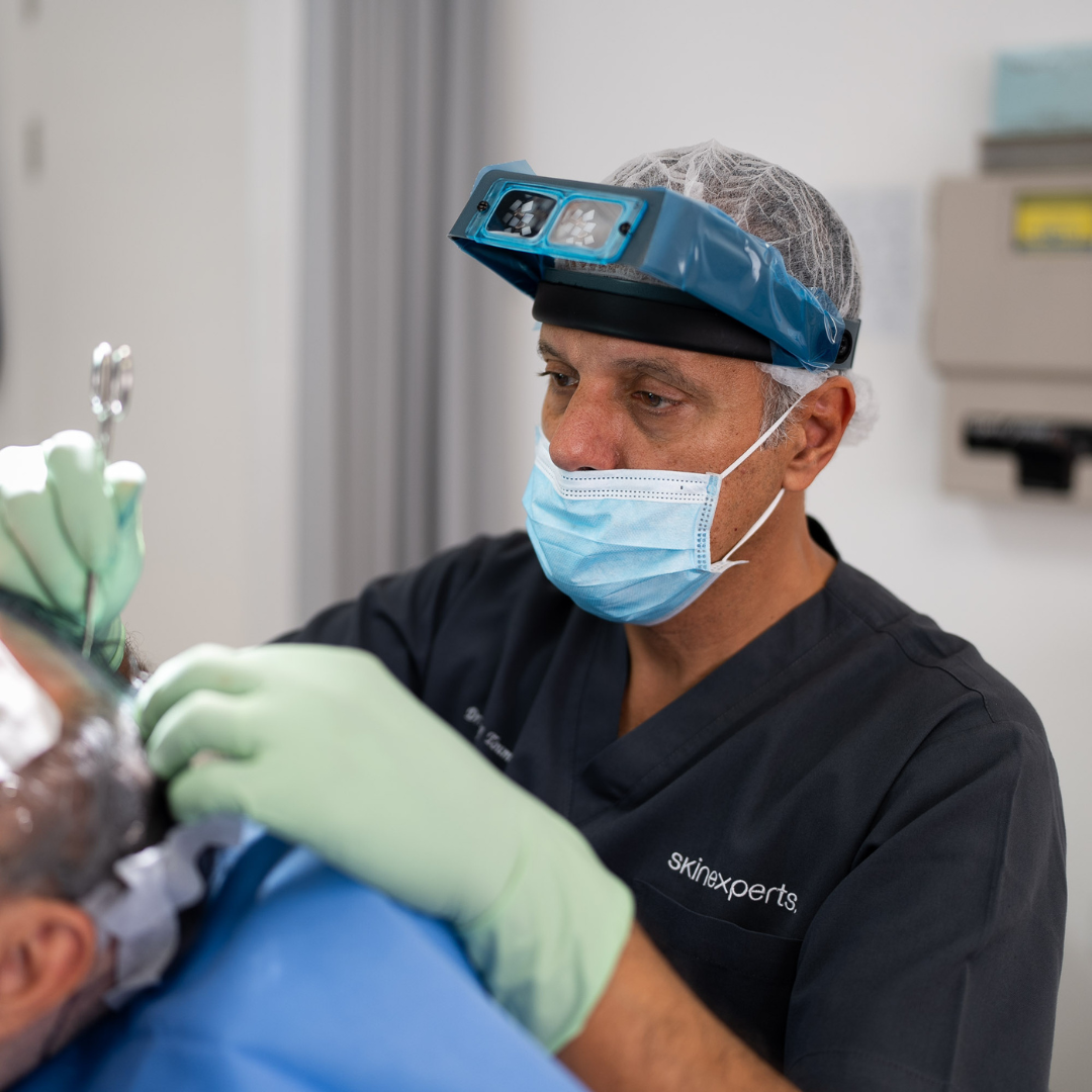 Dr. Dany Touma expertly performing a hair transplant procedure on a male patient